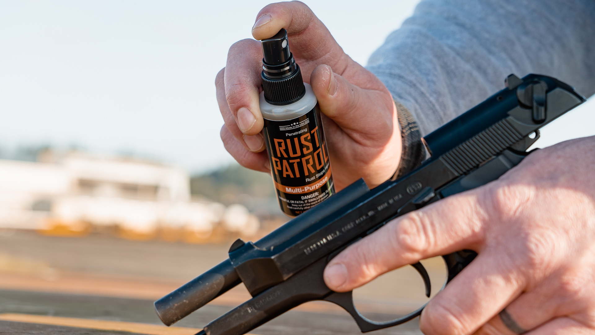 Spraying a bottle of 2 ounce Rust Patrol into the chamber of a pistol.